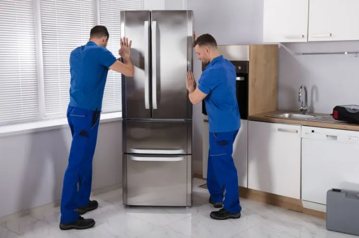 Umzugshelfer richten Kühlschrank aus Umzugshelfer richten Kühlschrank aus